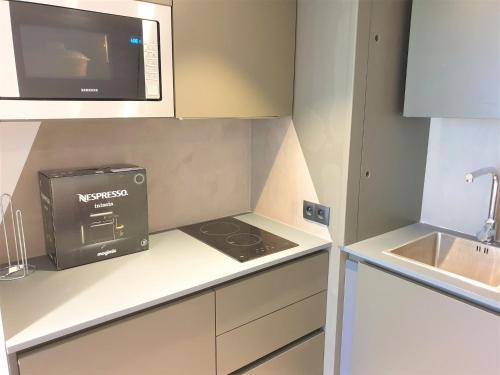 une petite cuisine avec un micro-ondes et une cuisinière dans l'établissement DUPLEX BALCON CENTRE MER 203, à Nice
