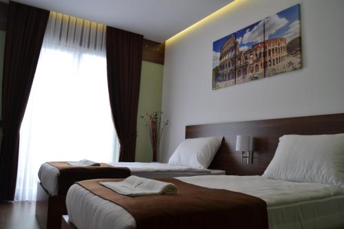 a hotel room with two beds and a window at Kuint Hotel in Peje