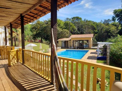 a hammock on a deck next to a swimming pool at Pousada Canto Verde in Serra do Cipo
