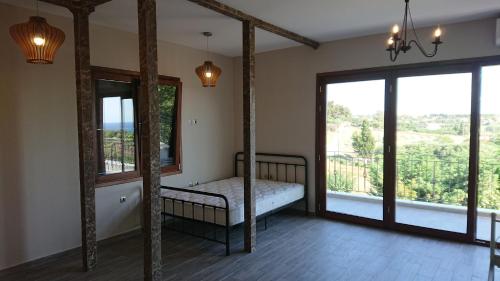 a bedroom with a bed and a large window at Stone house with seaview in Nea Potidaea