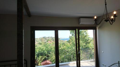 a room with a sliding glass door with a view at Stone house with seaview in Nea Potidaea