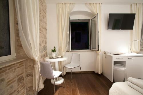 Habitación pequeña con 2 sillas, mesa y ventana en Speruna Luxury Inn, en Split