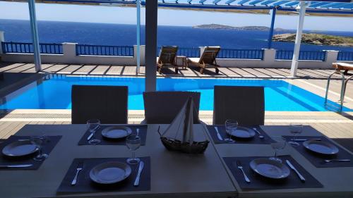 a dining table with a view of a pool at Blue Waves View in Batsi