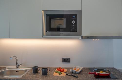 a kitchen counter with a sink and a microwave at ELIXIA in Tolo