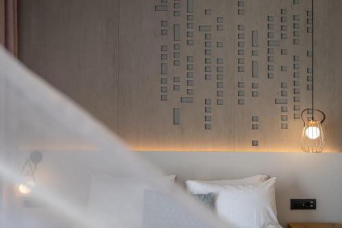 a bedroom with a bed and a light fixture at ELIXIA in Tolo