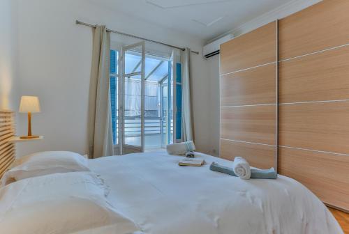 a bedroom with a large white bed and a large window at Maison Bianchi - 91 Promenade des Anglais in Nice