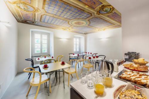 a room with tables and chairs and a coffered ceiling at Maison Alliod in Saint Vincent