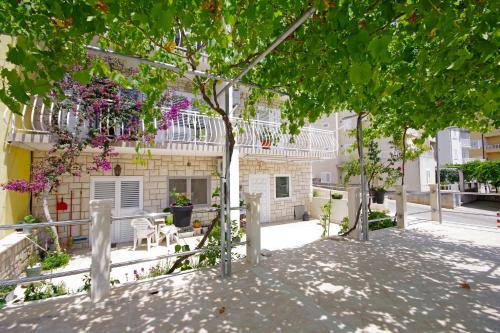 un edificio con un albero di fronte di Makarska sea view rooms a Makarska