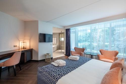 Habitación de hotel con cama y ventana grande en Van der Valk Hotel Wieringermeer, en Wieringerwerf