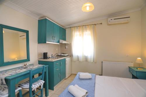 - une cuisine avec des placards bleus et un lavabo dans la chambre dans l'établissement ANTONIOS Skopelos studios apartments, à Skopelos