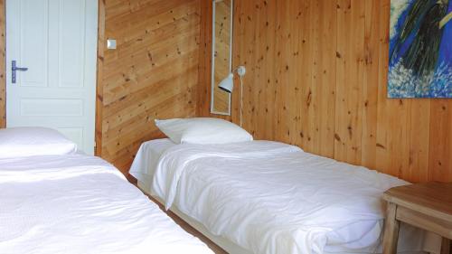 two beds in a room with wood paneling at Brekkestranda Fjordhotel in Brekke