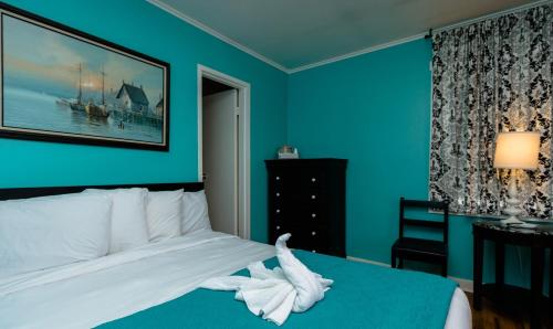a bedroom with a bed with a white towel on it at Charlroy Motel in Seaside Park