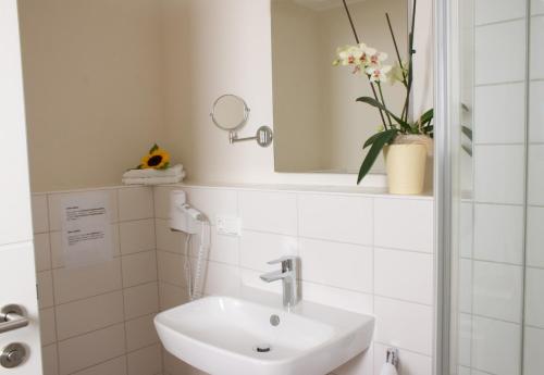 a white bathroom with a sink and a mirror at Hölbinger Alm - Apartments in Anger