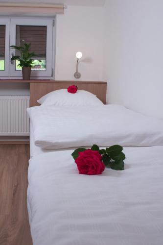 a red rose sitting on top of two beds at Hölbinger Alm - Apartments in Anger