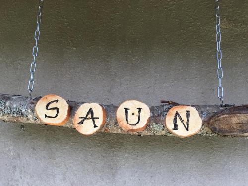 a wooden sign with the word savant hanging on a branch at Käänu puhkemaja in Rakvere