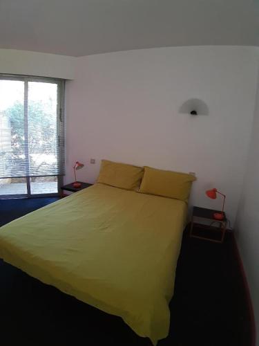 une chambre avec un lit jaune et une fenêtre dans l'établissement Superb architect villa 230m2 near beach south France, à Salses-le-Chateau
