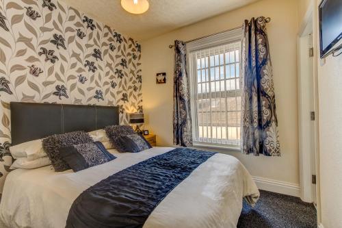 a bedroom with a large bed and a window at Hawthorn House in Blackpool