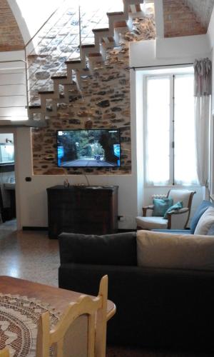 a living room with a couch and a tv at Casa Francesca Torre Saracena in Dolcedo