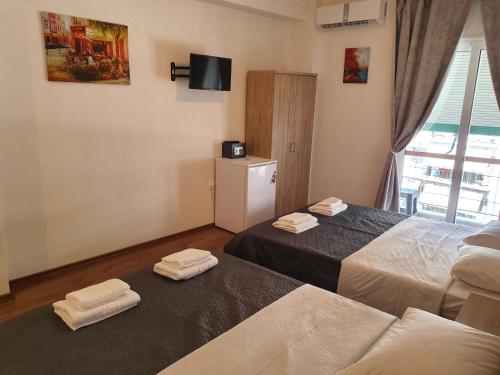 a hotel room with two beds and a television at City Centre Stylish rooms in Athens