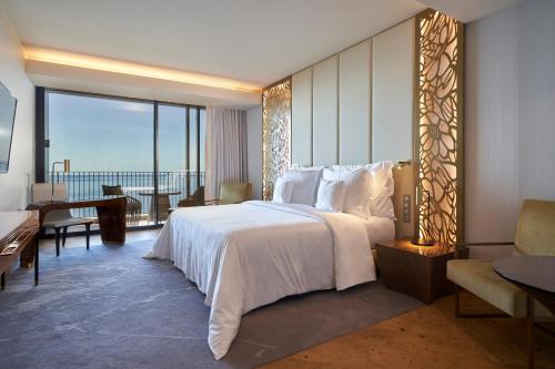 a bedroom with a large white bed and a large window at Savoy Palace - The Leading Hotels of the World - Savoy Signature in Funchal