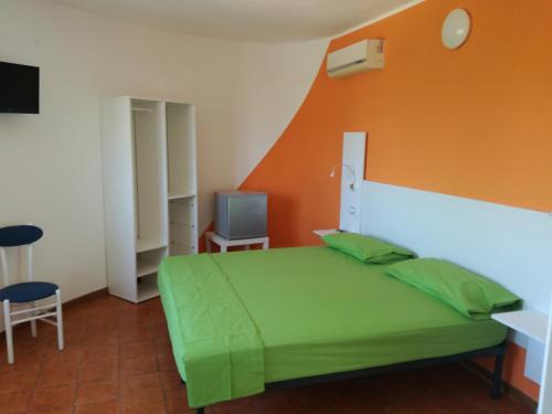 a bedroom with a green bed and an orange wall at B&B Villa Napoli in Battipaglia