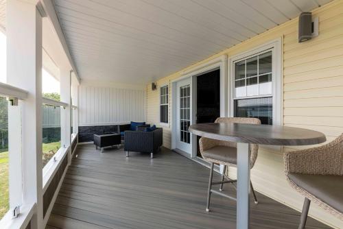 a screened porch with a table and chairs on a house at Lantern Hill & Hollow in Ingonish Beach