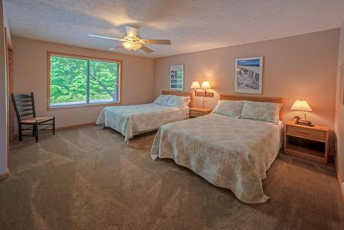 - une chambre avec 2 lits et un ventilateur de plafond dans l'établissement Agaming Golf Resort, à Kewadin