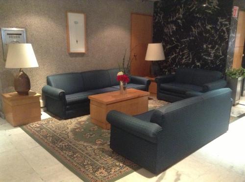 a living room with two blue couches and a table at Hotel Sevilla in Mexico City