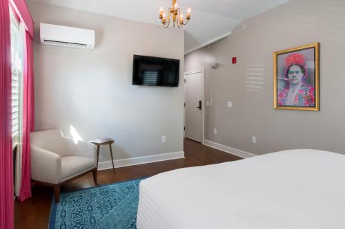 a bedroom with a bed and a chair and a television at The Germantown Inn in Nashville