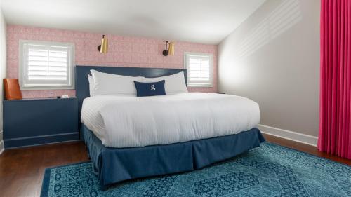 a bedroom with a large bed and two windows at The Germantown Inn in Nashville