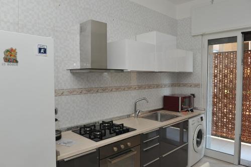 a kitchen with a stove and a sink and a microwave at Casa Sarahouse in Taranto