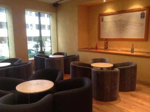 a waiting room with tables and chairs and a whiteboard at Hotel Sevilla in Mexico City