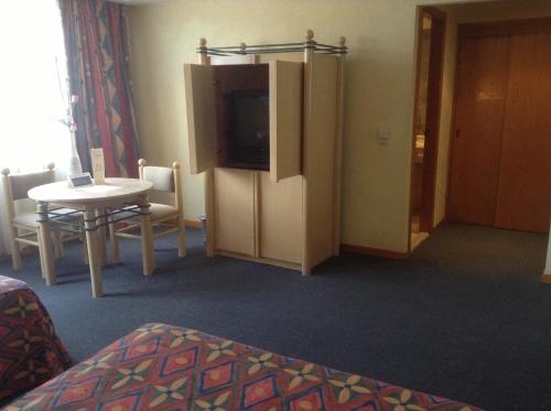 a hotel room with a table and a tv and a room at Hotel Sevilla in Mexico City