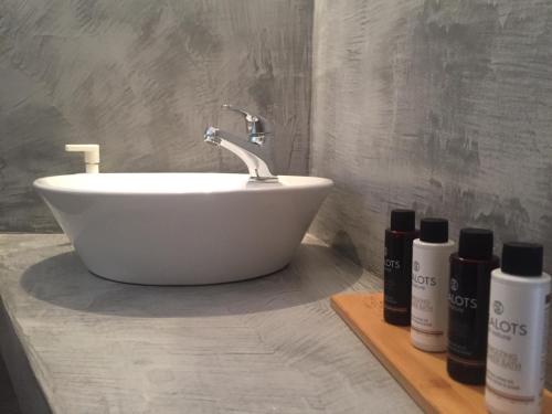 a bathroom with a white sink and two bottles of soap at Galini Rooms & Apartments in Finikas