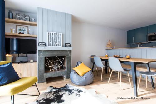 un salon avec une table et des chaises et une cheminée dans l'établissement Apartment Chloe, à Chamonix-Mont-Blanc