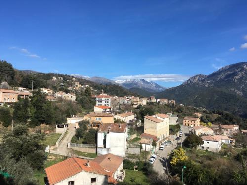 une ville sur une colline avec des montagnes en arrière-plan dans l'établissement Petite maison en campagne chic près de la plage, à Vico