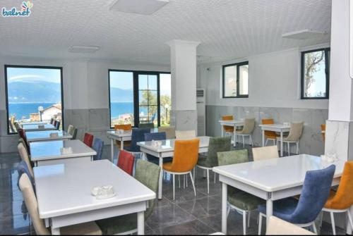 een eetkamer met tafels en stoelen en ramen bij Erpey Ferah Apart Otel in Balıkesir