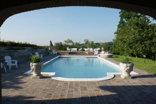 a swimming pool in a yard with two potted plants at Tenuta Terensano in Monleale