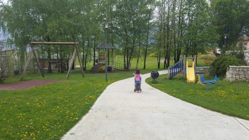 a little girl walking down a sidewalk in a park at Agritur Piccolo Fiore B&B in Taio