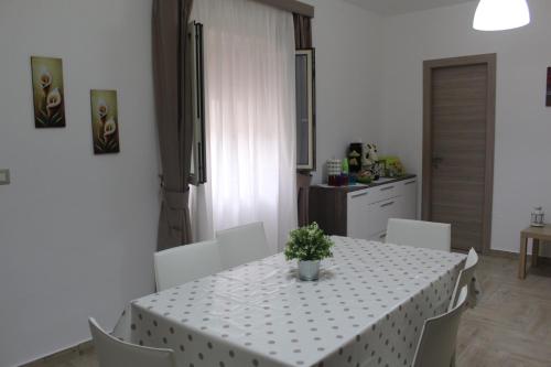 a dining room table with a white table cloth and a plant on it at AFFITTACAMERE LA TRAVERSA in San Cataldo