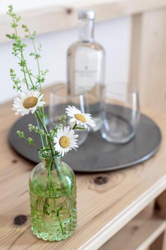 a vase with flowers in it on a table at Hotel Drumlerhof in Campo Tures