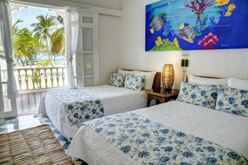 two beds in a room with a view of the ocean at Hotel Agua Azul Beach Resort in Baru