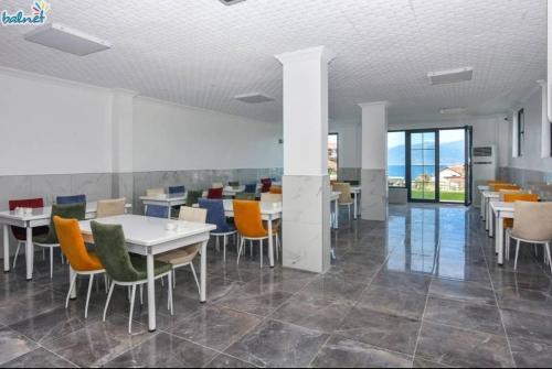 een eetkamer met tafels en stoelen en ramen bij Erpey Ferah Apart Otel in Balıkesir