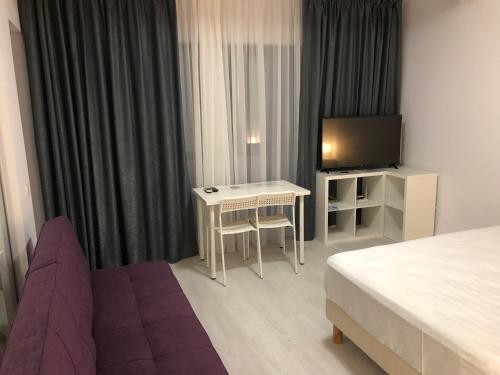 a hotel room with a bed and a couch and a tv at 21 Residence Apartments in Bucharest