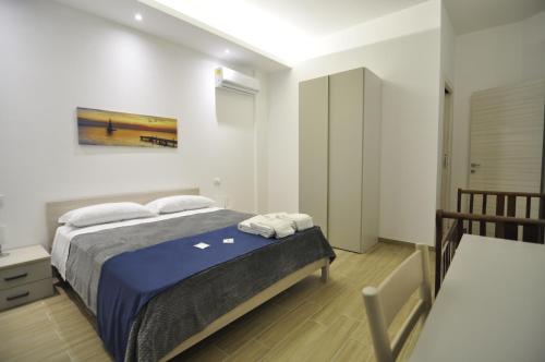 a bedroom with a bed with blue sheets and white pillows at IL GIARDINO NASCOSTO in Portopalo
