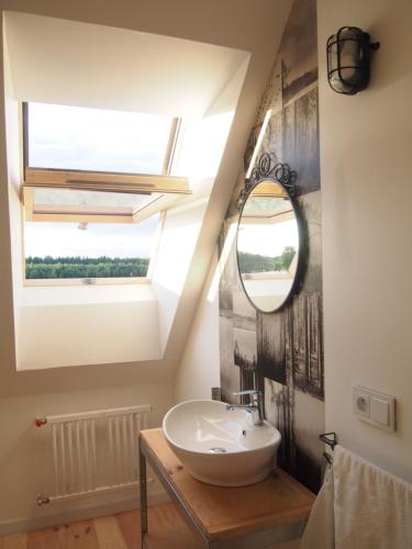 ein Bad mit einem Waschbecken und einem Spiegel in der Unterkunft Leśna Kryjówka in Trzebciny