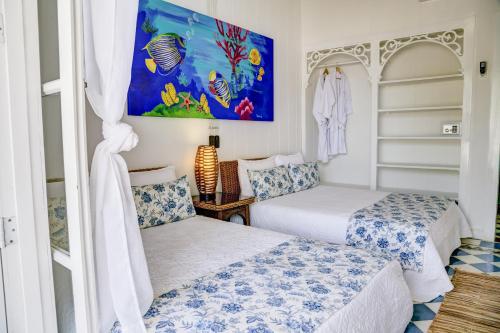a bedroom with two beds and a painting on the wall at Hotel Agua Azul Beach Resort in Baru