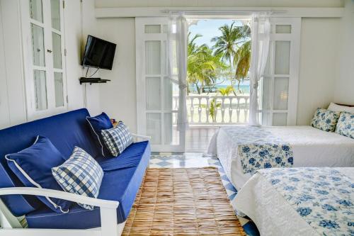 a living room with two beds and a blue couch at Hotel Agua Azul Beach Resort in Baru