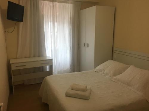 1 dormitorio con 1 cama con 2 toallas en Hostal O Patron, en Santiago de Compostela