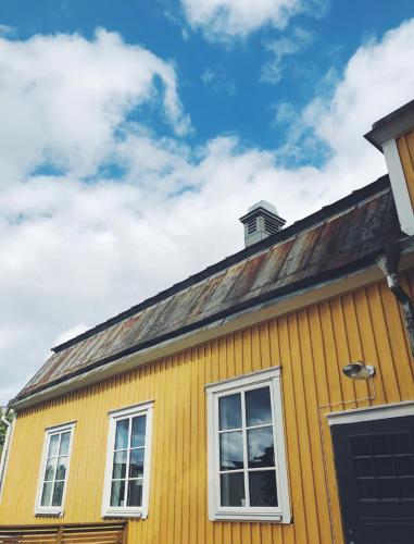 a yellow house with two windows and a roof at Lindens Bed&Breakfast in Mellerud